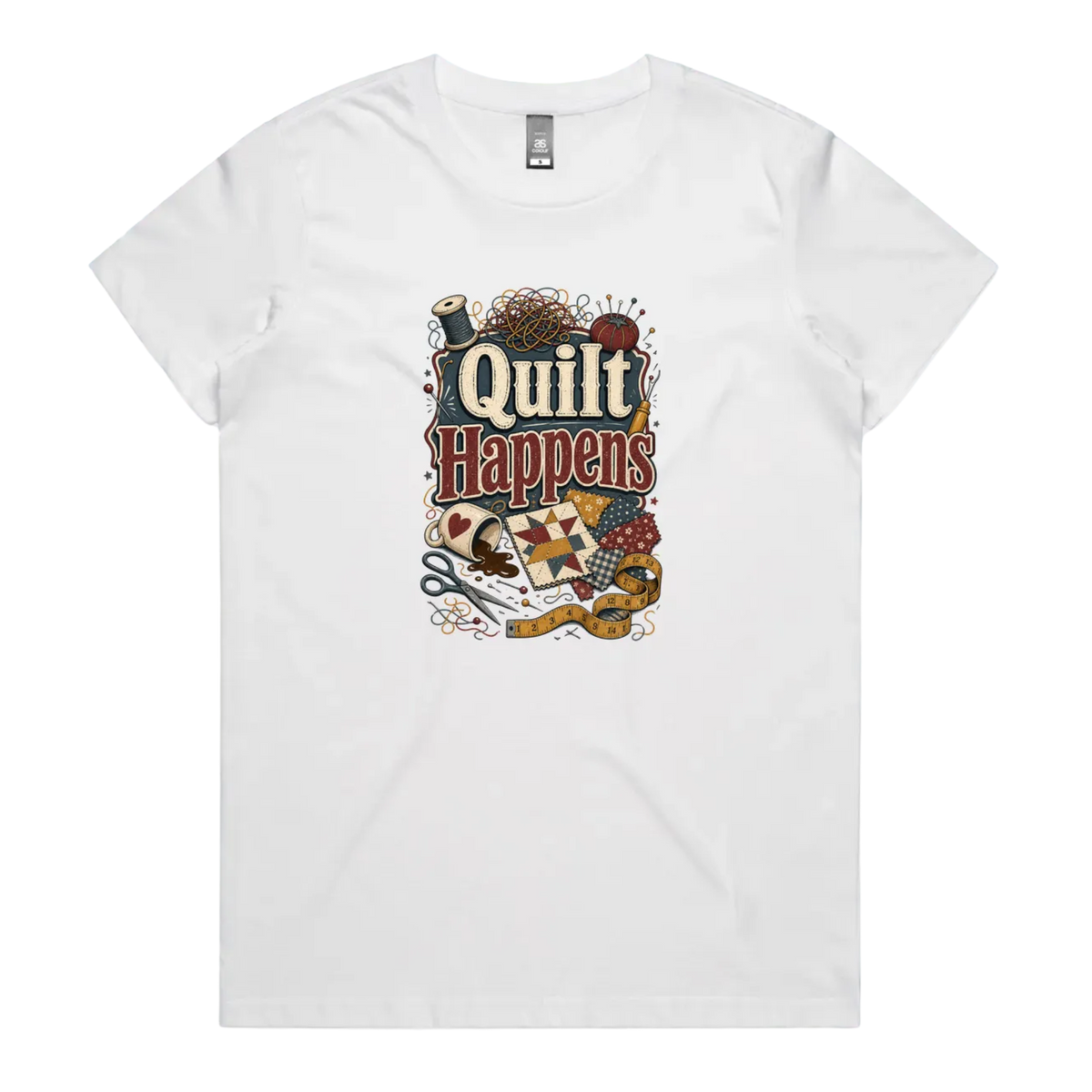 A white short-sleeve crewneck t-shirt featuring a colorful graphic print on the front with the text 'Quilt Happens' surrounded by quilting tools and fabrics.