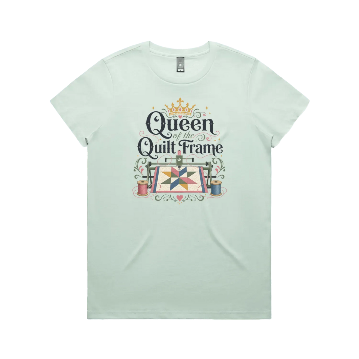 A pale mint green short-sleeve t-shirt with a graphic print on the front that reads 'Queen of the Quilt Frame' in black script, decorated with a gold crown, a quilt design, and spools of thread.