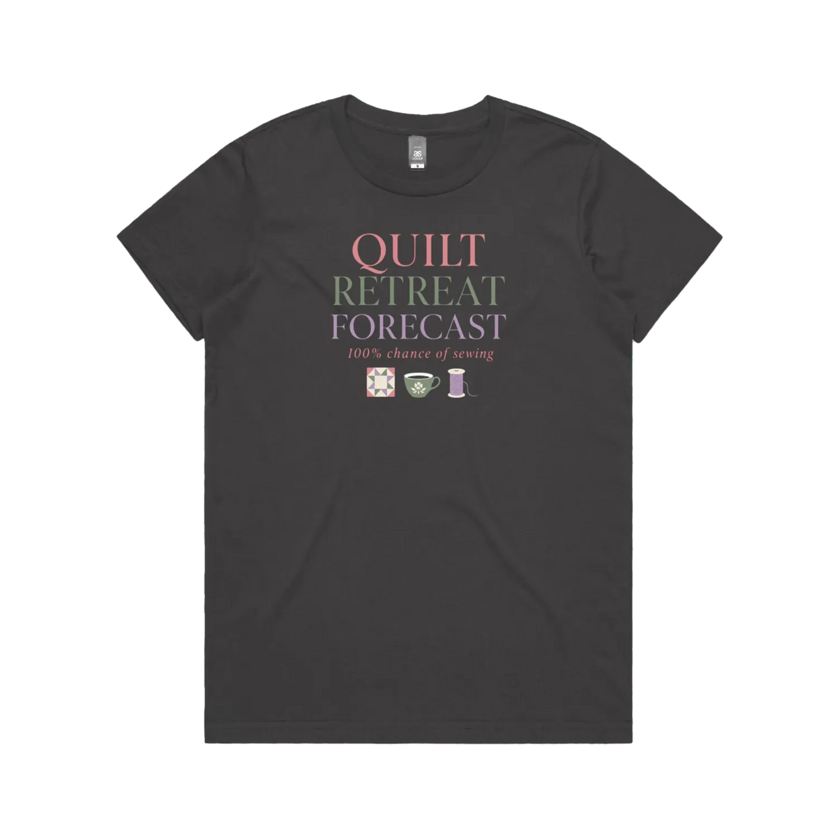 A charcoal grey short-sleeve crewneck t-shirt featuring a graphic print on the front that reads 'QUILT RETREAT FORECAST, 100% chance of sewing' in pink, green, and white lettering, with small sewing-themed icons below.