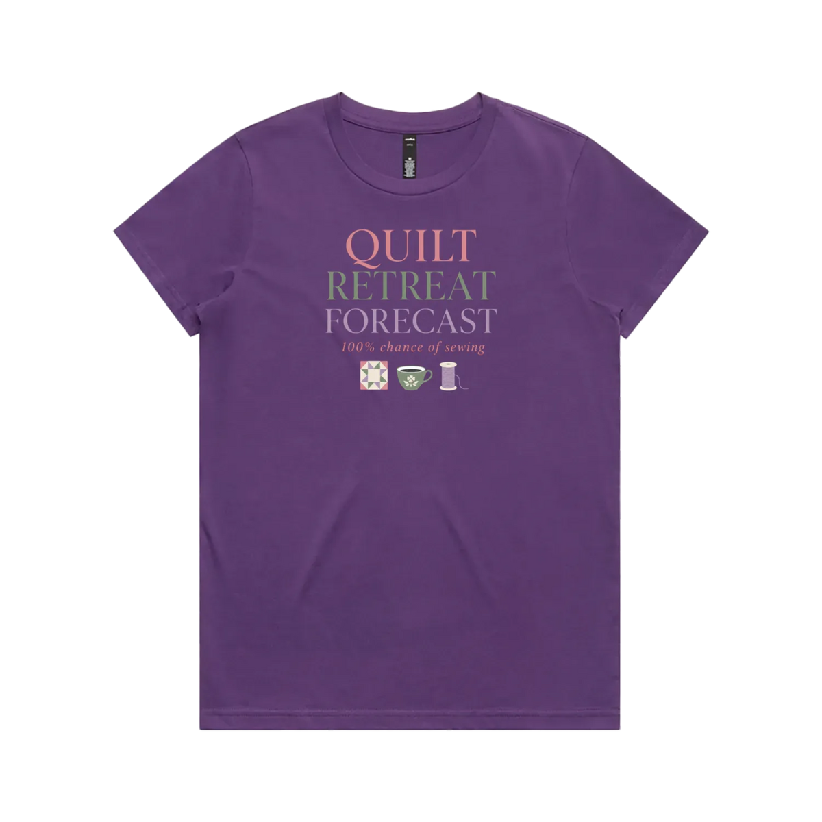 A purple short-sleeve crewneck t-shirt featuring a graphic print on the front that reads 'QUILT RETREAT FORECAST, 100% chance of sewing' in pink, green, and white lettering, with small sewing-themed icons below.