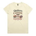 A light butter yellow short-sleeve crewneck t-shirt featuring a retro-style graphic print on the front. The graphic reads 'Quilters Run on Caffeine and Cotton' in stylized fonts, accompanied by illustrations of a fabric stack, a mug of coffee, a pincushion, and a spool of thread.