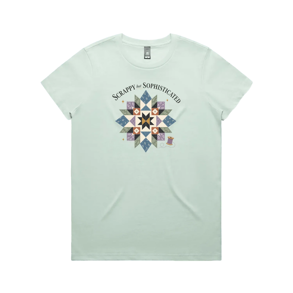 A pale mint green short-sleeve crewneck tshirt with the words 'Scrappy but Sophisticated' above a large star quilt block with a purple thread spool on the bottom right.