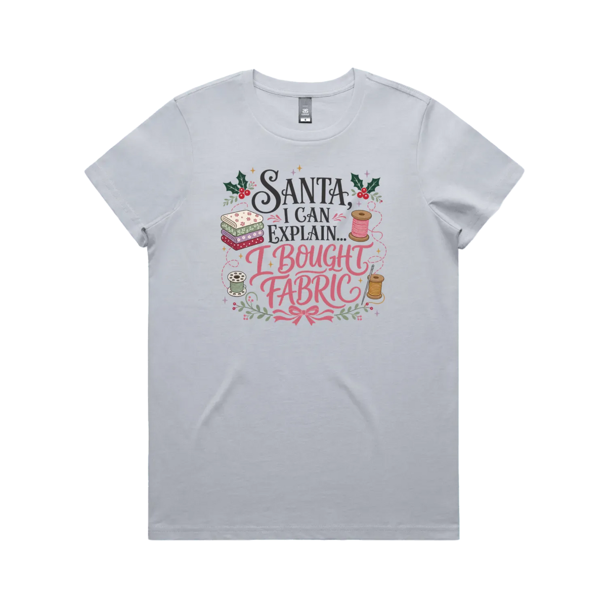 A powder blue short-sleeve crewneck t-shirt with a festive Christmas-themed graphic on the chest. The graphic features the text 'Santa, I Can Explain...I Bought Fabric'.