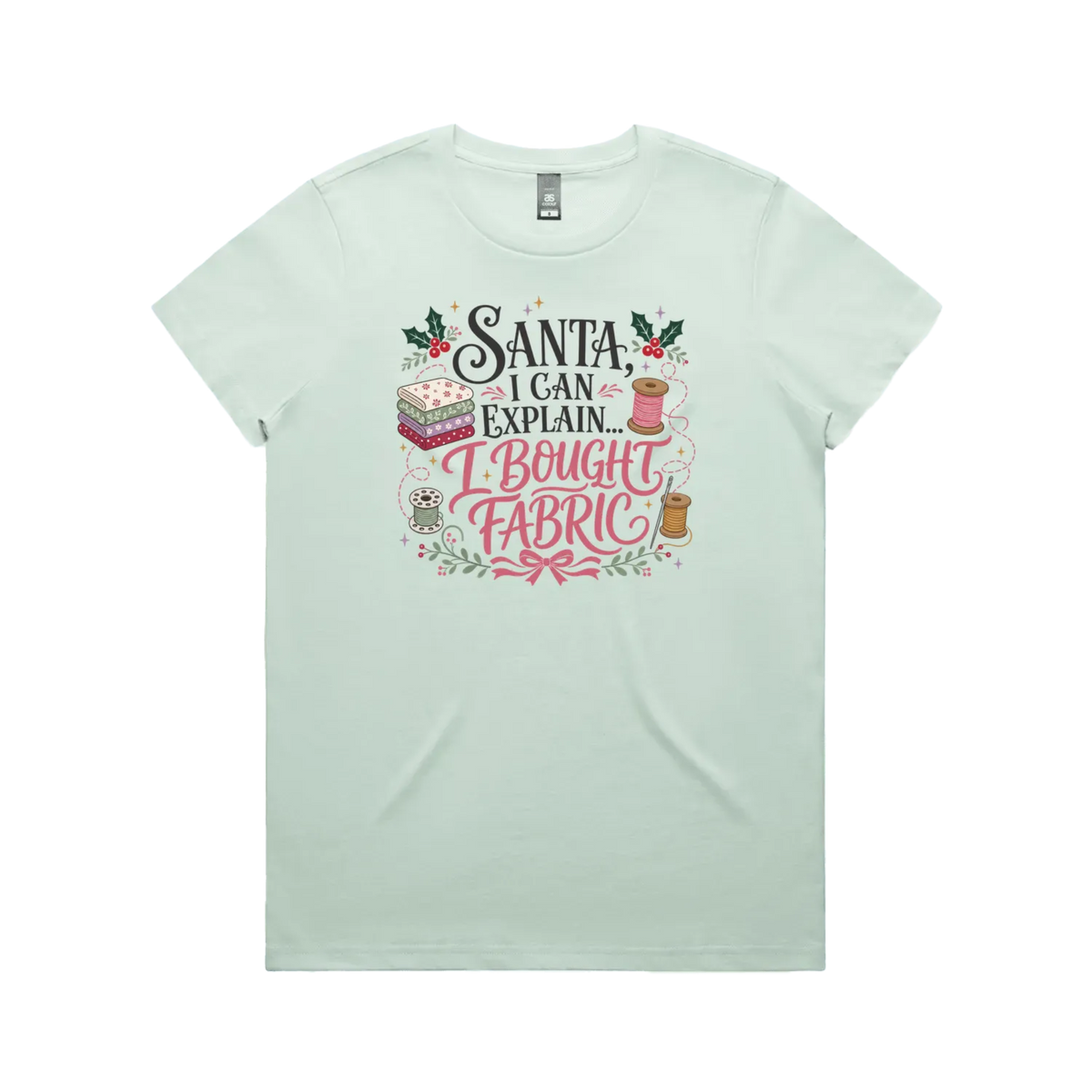 A pale seafoam greenshort-sleeve crewneck t-shirt with a festive Christmas-themed graphic on the chest. The graphic features the text 'Santa, I Can Explain...I Bought Fabric'.