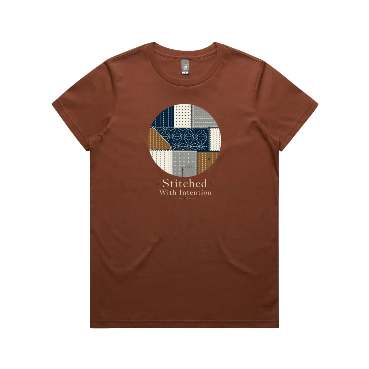 A clay brown short-sleeve crewneck t-shirt featuring a circular graphic on the chest with geometric sashiko stitched patterns in navy, beige, and brown, with the text 'Stitched With Intention' printed below.