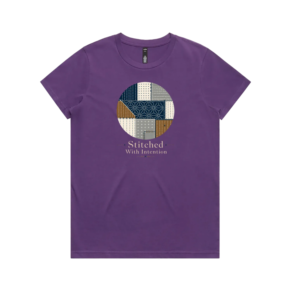 A purple short-sleeve crewneck t-shirt featuring a circular graphic on the chest with geometric sashiko stitched patterns in navy, beige, and brown, with the text 'Stitched With Intention' printed below.