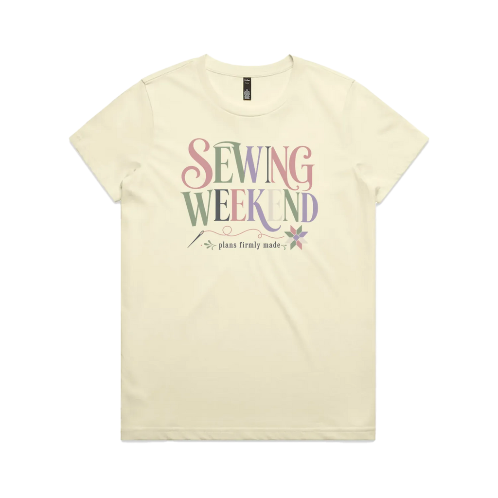 A pale butter yellow short-sleeve t-shirt with the words 'Sewing Weekend plans firmly made' across the front in multi-coloured letters.