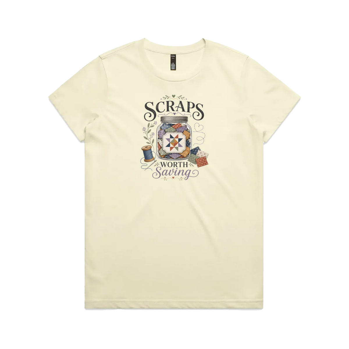 A pale butter yellow short-sleeve t-shirt with the graphic 'Scraps Worth Saving' surrounding a jar filled with small fabric swatches.