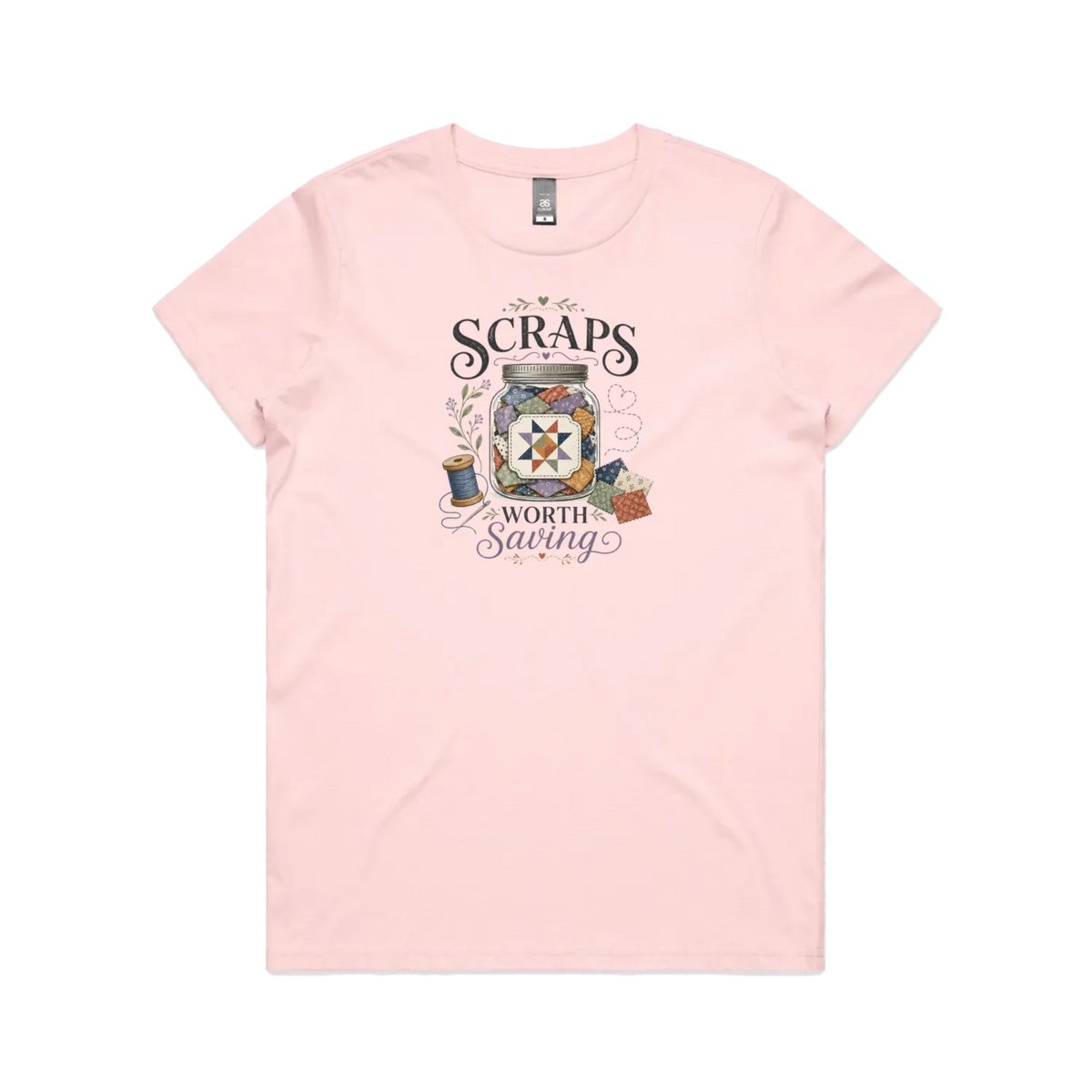 A pale pink short-sleeve t-shirt with the graphic 'Scraps Worth Saving' surrounding a jar filled with small fabric swatches.