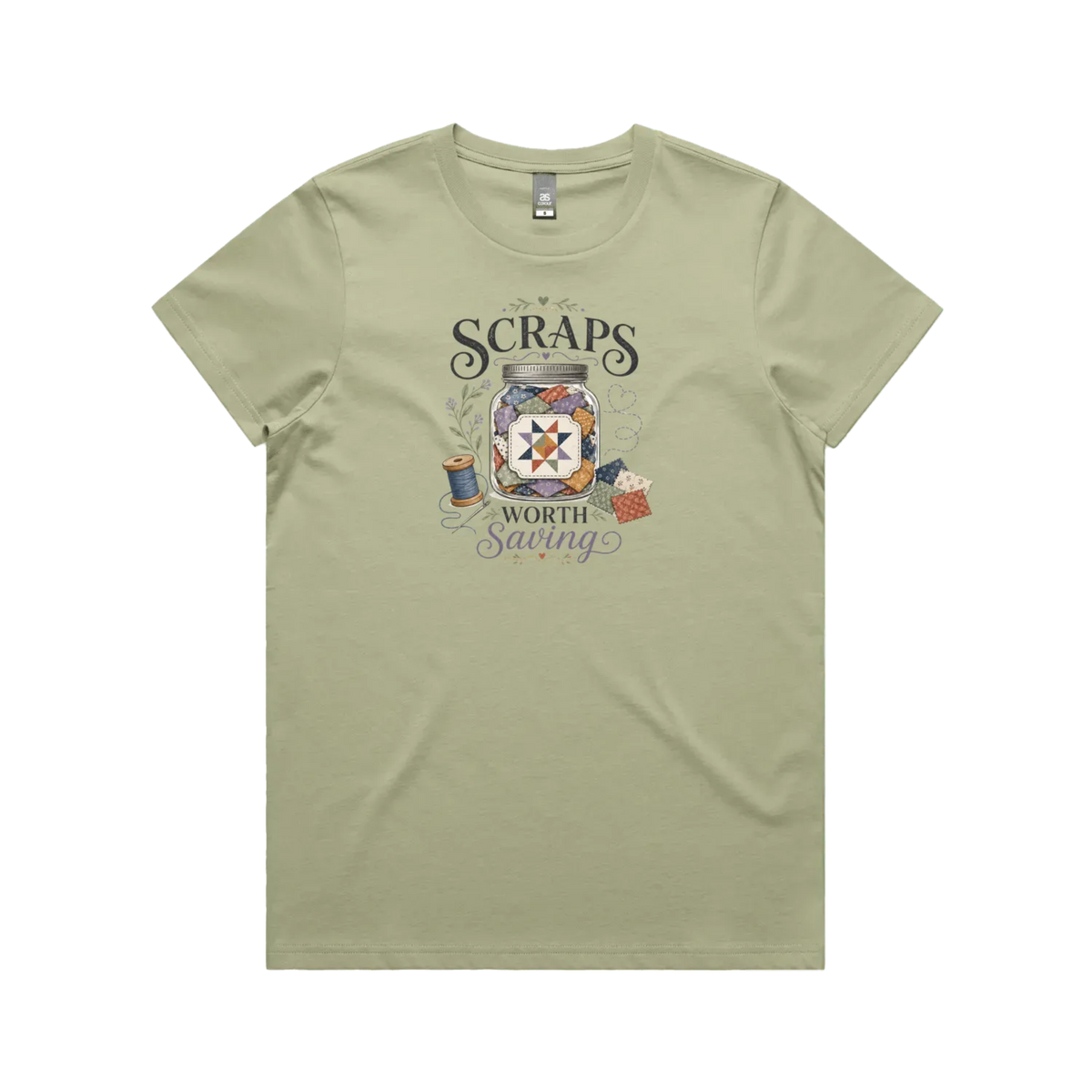 A pistachio green short-sleeve t-shirt with the graphic 'Scraps Worth Saving' surrounding a jar filled with small fabric swatches.