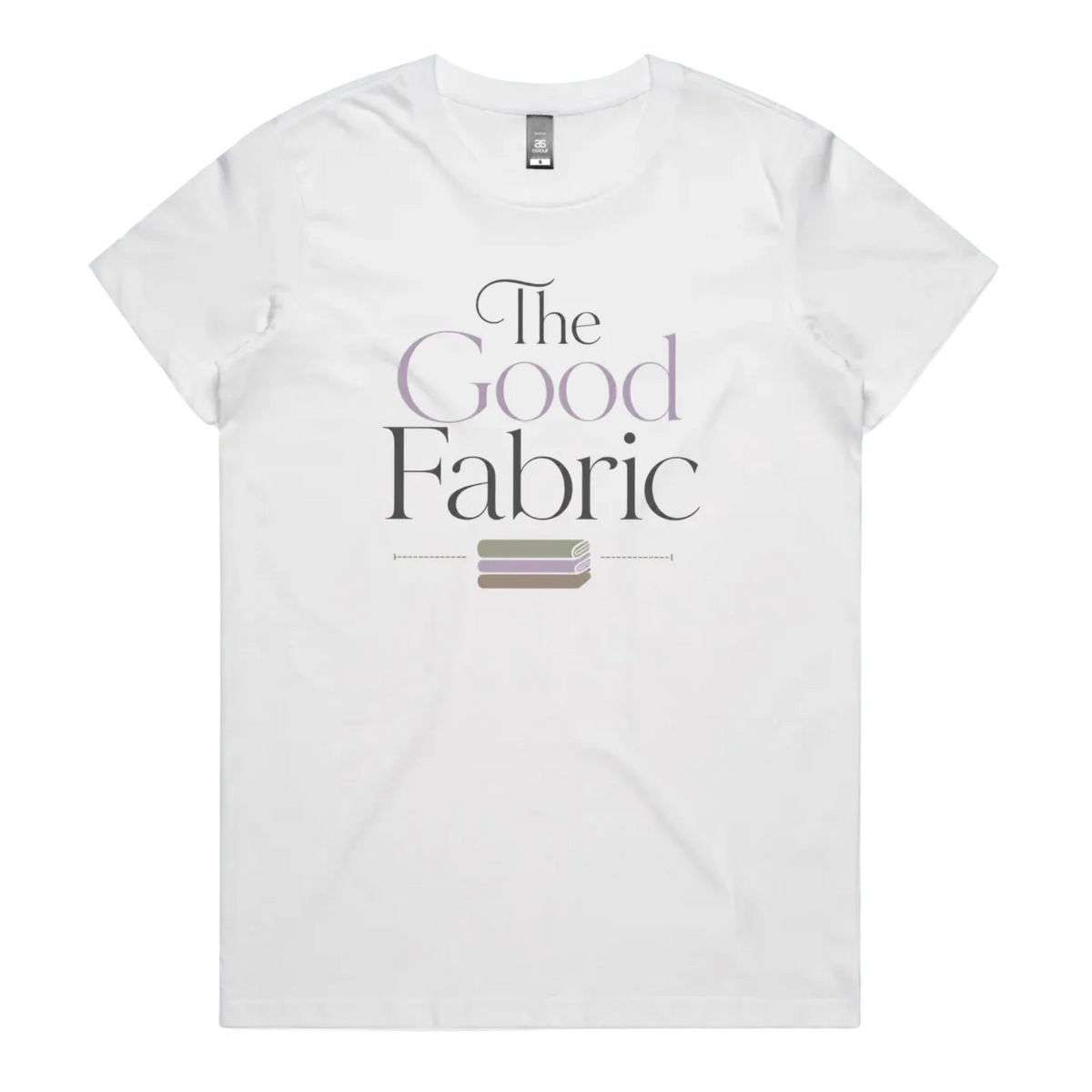 A white short-sleeve crewneck t-shirt featuring a graphic print on the front that reads 'The Good Fabric' in dark gray and lavender lettering, with a small fabric bundle illustration below.