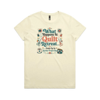 A pale butter yellow short-sleeve graphic t-shirt with the words 'What Happens at Quilt Retreat...ends up in another project bag'. The words are surrounded by quilt blocks thread spools, scissors, a coffee mug and zippered bag.