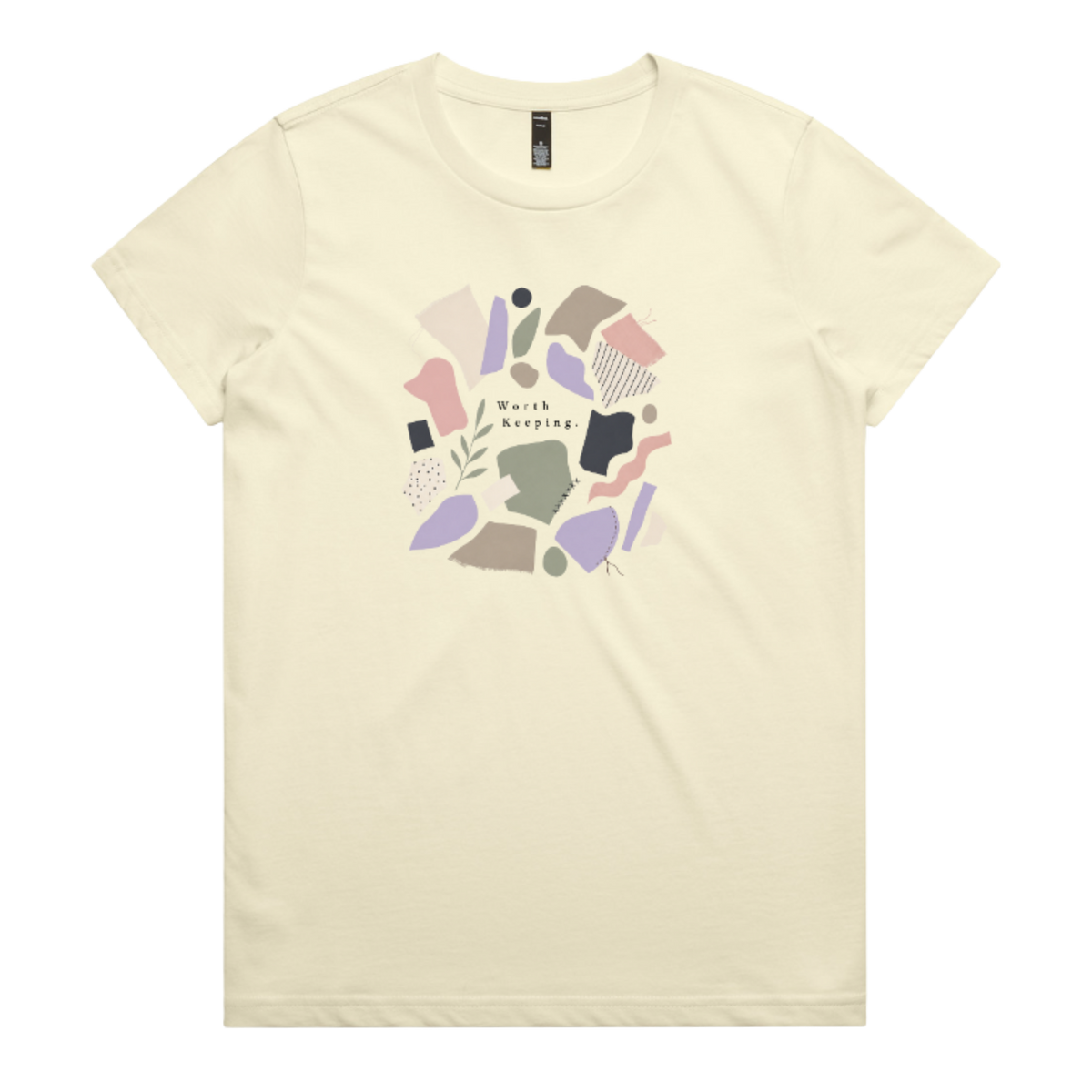 A pale yellow crewneck t-shirt featuring a central graphic of abstract pastel shapes in pink, purple, beige, and brown, with the text 'Worth Keeping' written in the center.